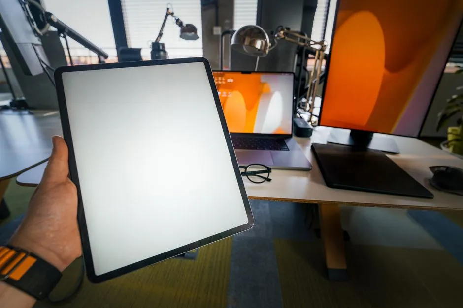 Laptop screen showing a grid of colour words for a Stroop focus task, room lit by a window