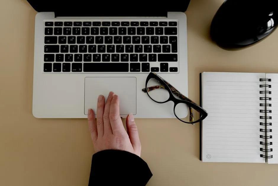 Hand resting on a trackpad with a millisecond reaction time reading shown on the laptop screen
